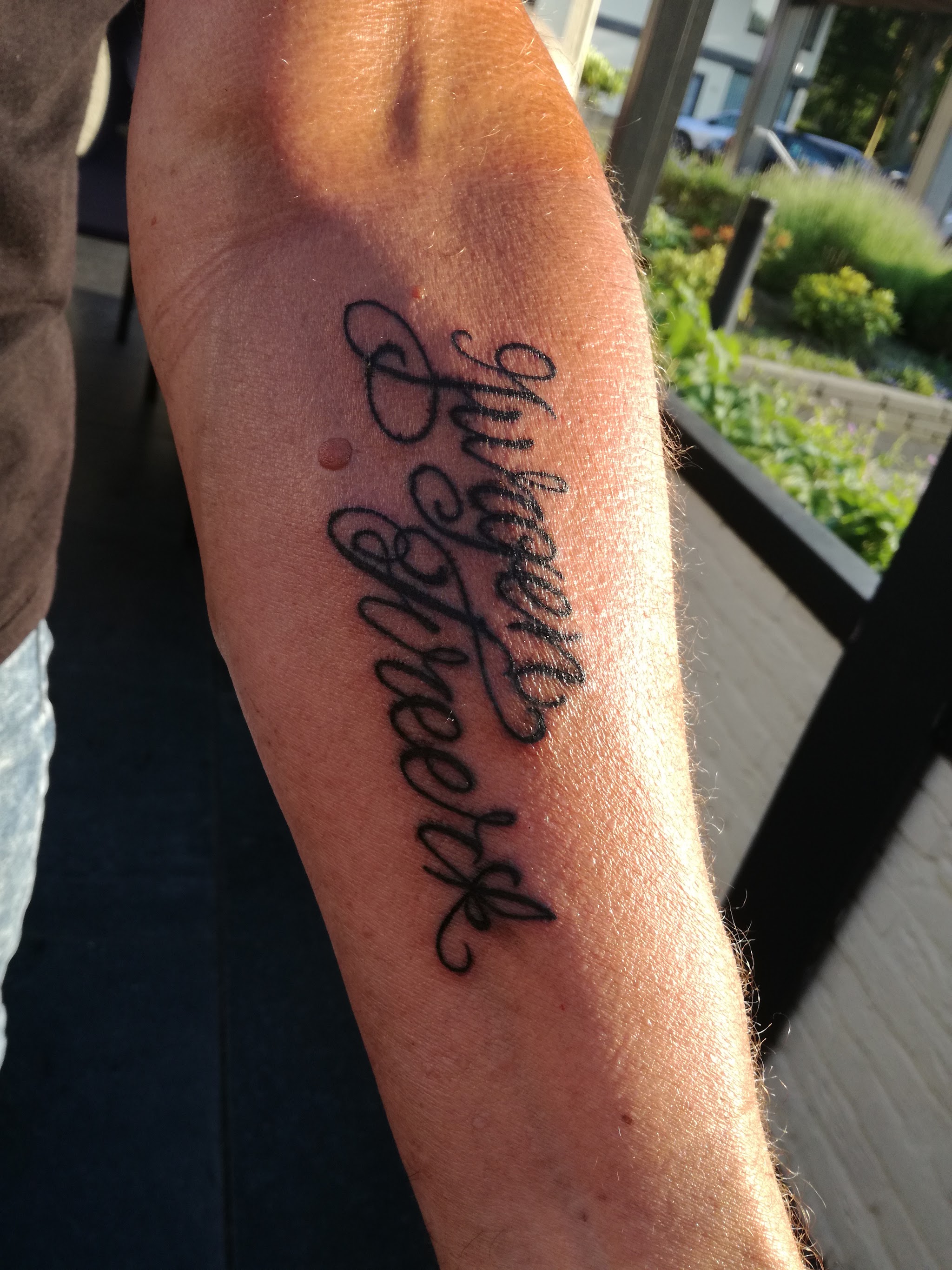 Lettering in zwart schrift op een onderarm