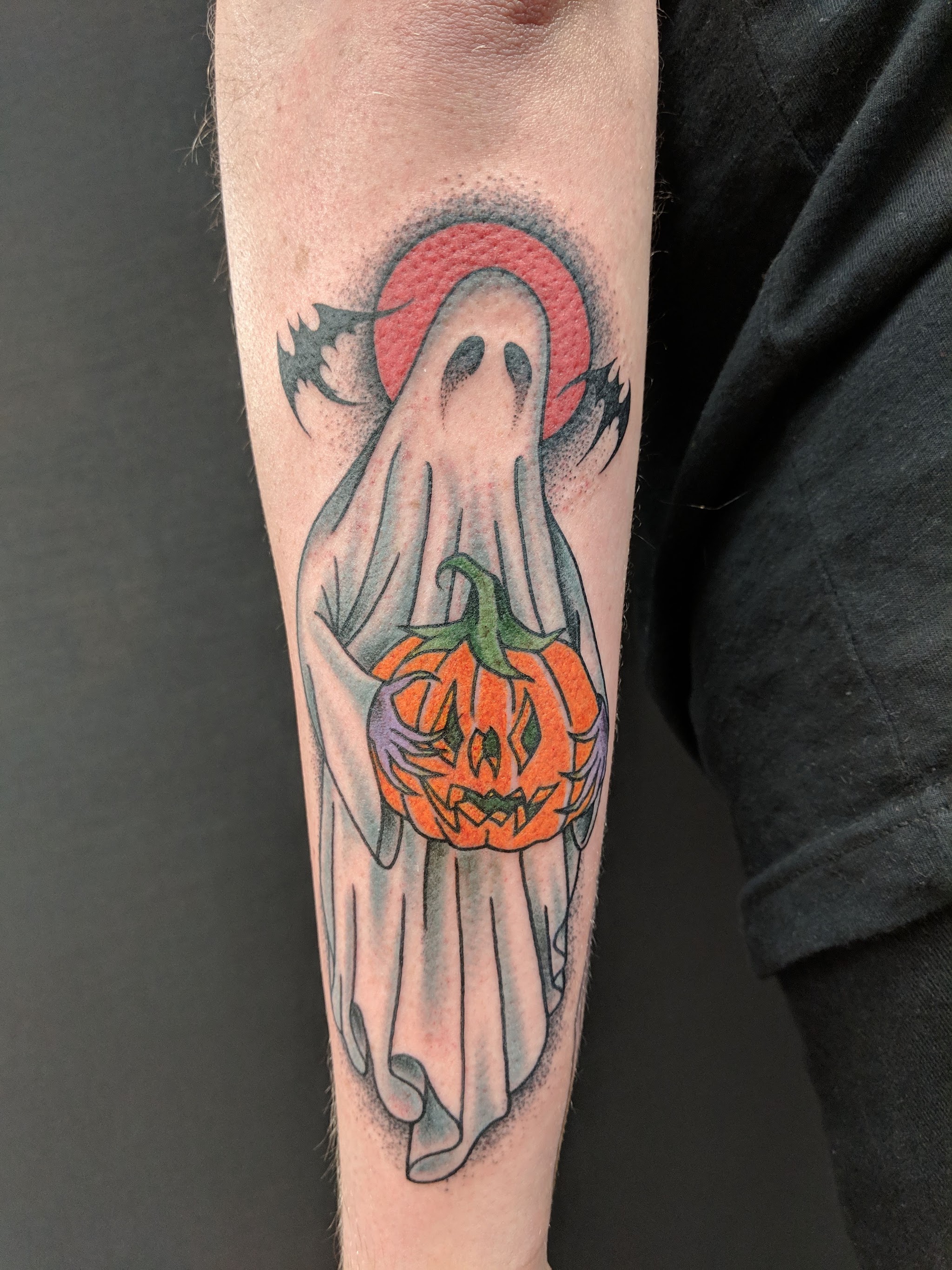 Spookje met een pompoen en een rode maan op een onderarm